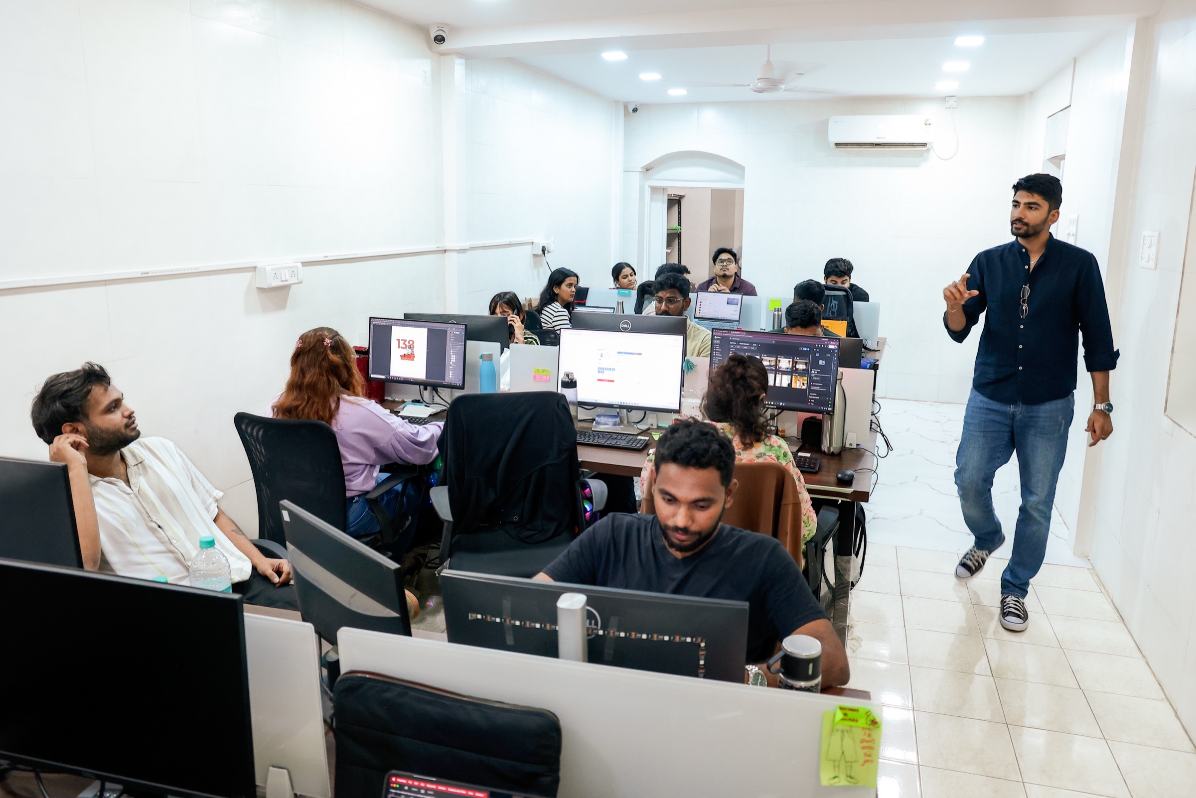 Manan walking through the MarketinCrew Mumbai office while the crew works at their desks